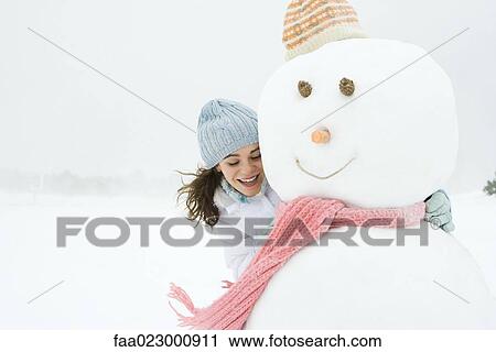 Female embracing snowman, smiling, looking down portrait View Large Photo Image Stock Image - Female embracing snowman, smiling, looking down portrait. Fotosearch