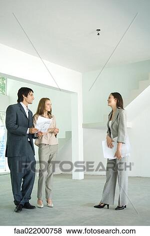 Female real estate agent showing house to young couple View Large Photo Image Stock Photo - Female real estate agent showing house to young couple. Fotosearch