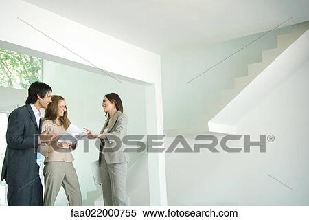 Female real estate agent showing house to young couple, pointing to blueprints View Large Photo Image Stock Photography - Female real estate agent showing house to young couple, pointing to blueprints. Fotosearch