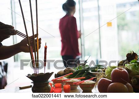 Food and candles on table as religious offering, person lighting incense View Large Photo Image Stock Image - Food and candles on table as religious offering, person lighting incense. Fotosearch