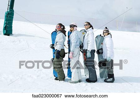 Four young snowboarders standing, lined up, looking up View Large Photo Image Stock Photo - Four young snowboarders standing, lined up, looking up. Fotosearch
