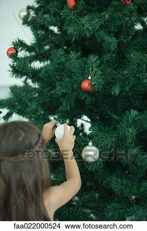 Picture - Girl decorating Christmas tree. Fotosearch