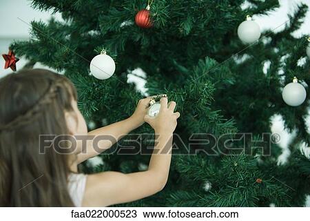 Girl decorating Christmas tree View Large Photo Image Stock Image - Girl decorating Christmas tree. Fotosearch