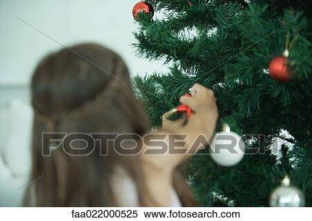 Girl decorating Christmas tree View Large Photo Image Stock Photography - Girl decorating Christmas tree. Fotosearch