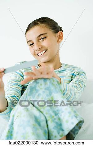 Girl filing nails, smiling View Large Photo Image Stock Image - Girl filing nails, smiling. Fotosearch