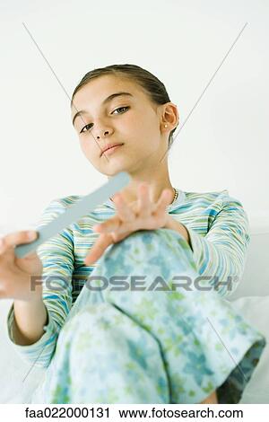 Stock Image - Girl filing nails. Fotosearch