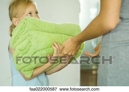 Girl handing mother stack of towels View Large Photo Image Stock Photo - Girl handing mother stack of towels. Fotosearch