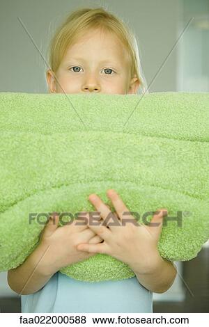 Girl holding stack of towels, portrait View Large Photo Image Stock Photo - Girl holding stack of towels, portrait. Fotosearch