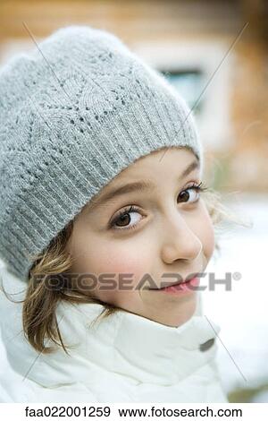 Stock Photo - Girl in winter clothes smiling at camera, close-up. Fotosearch
