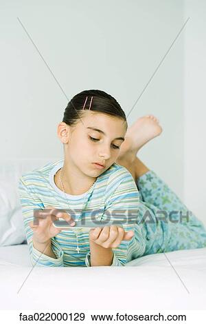 Girl lying on stomach, filing nails View Large Photo Image Stock Photo - Girl lying on stomach, filing nails. Fotosearch