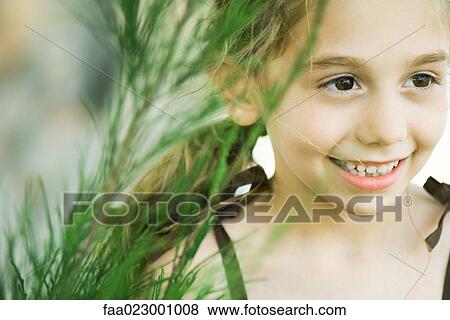 Girl next to tall grass, smiling, looking away, portrait View Large Photo Image Stock Photo - Girl next to tall grass, smiling, looking away, portrait. Fotosearch