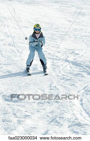 Girl skiing down ski slope, full length View Large Photo Image Picture - Girl skiing down ski slope, full length. Fotosearch