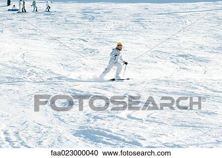 Girl skiing down ski slope, full length, skiers in background View Large Photo Image Stock Image - Girl skiing down ski slope, full length, skiers in background. Fotosearch