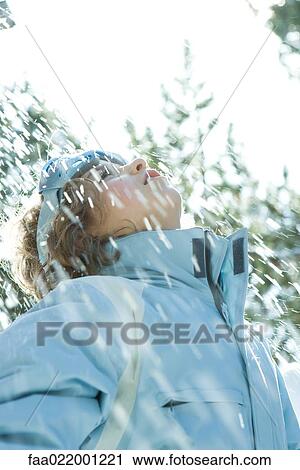 Girl standing in falling snow, head back, looking up View Large Photo Image Stock Image - Girl standing in falling snow, head back, looking up. Fotosearch