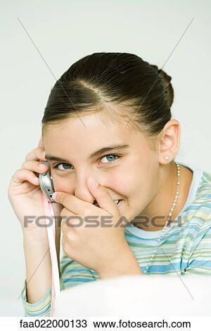 Girl talking on cell phone, covering mouth and giggling View Large Photo Image Stock Image - Girl talking on cell phone, covering mouth and giggling. Fotosearch