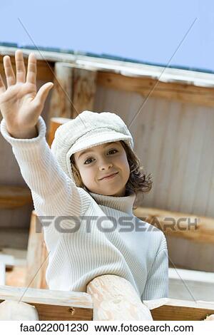 Girl waving to camera from deck of chalet, low angle view View Large Photo Image Stock Image - Girl waving to camera from deck of chalet, low angle view. Fotosearch
