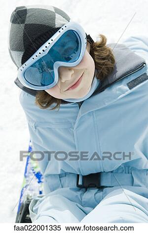 Girl wearing ski gear, sitting in snow, smiling at camera View Large Photo Image Stock Photography - Girl wearing ski gear, sitting in snow, smiling at camera. Fotosearch