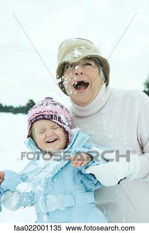 Grandmother and granddaughter being hit with snowballs, smiling View Large Photo Image Stock Photography - Grandmother and granddaughter being hit with snowballs, smiling. Fotosearch