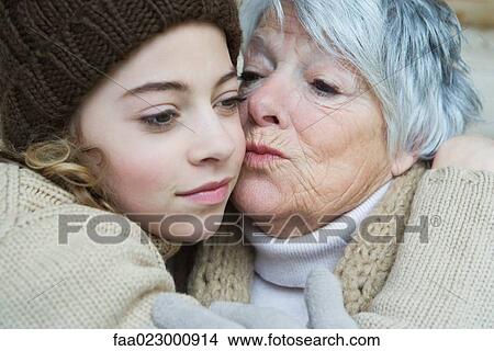 Picture - Grandmother kissing teenage girl on the cheek, portrait. Fotosearch