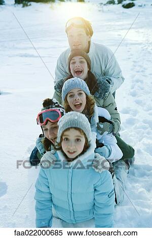 Group kneeling in snow, lined up one behind the other, smiling and laughing View Large Photo Image Stock Photography - Group kneeling in snow, lined up one behind the other, smiling and laughing. Fotosearch