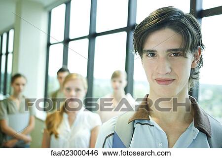 Group of college students, focus on young man in foreground, smiling at camera View Large Photo Image Stock Photograph - Group of college students, focus on young man in foreground, smiling at camera. Fotosearch
