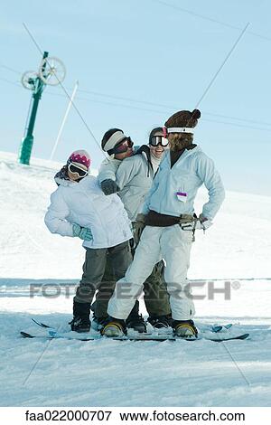 Stock Photo - Group of snowboarders posing in snow, full length. Fotosearch