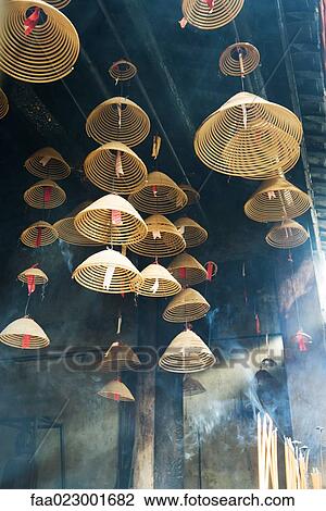 Stock Image - Incense hanging from ceiling in Chinese temple, low angle view. Fotosearch