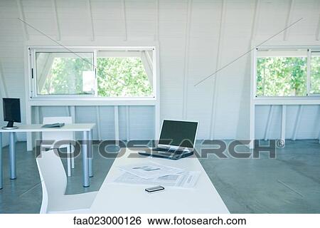 Laptop computer, cell phone, and newspaper on desk in office View Large Photo Image Stock Photograph - Laptop computer, cell phone, and newspaper on desk in office. Fotosearch