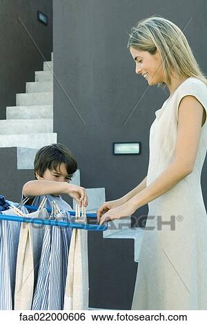 Little boy helping mother hang laundry on drying rack View Large Photo Image Stock Photograph - Little boy helping mother hang laundry on drying rack. Fotosearch