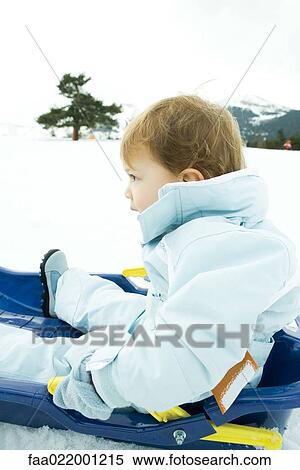 Little boy sitting on sled, looking away, side view View Large Photo Image Stock Photography - Little boy sitting on sled, looking away, side view. Fotosearch