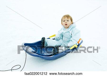 Little boy sitting on sled, looking up, furrowing brow View Large Photo Image Stock Image - Little boy sitting on sled, looking up, furrowing brow. Fotosearch