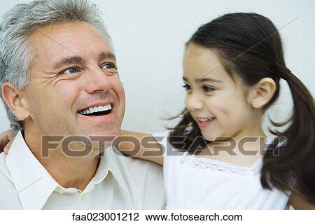 Little girl with arm around man, smiling, man smiling and looking away, portrait View Large Photo Image Stock Image - Little girl with arm around man, smiling, man smiling and looking away, portrait. Fotosearch