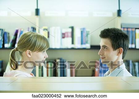 Male and female college students face to face in library View Large Photo Image Stock Image - Male and female college students face to face in library. Fotosearch
