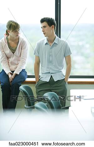 Male and female college students chatting by window View Large Photo Image Stock Image - Male and female college students chatting by window. Fotosearch