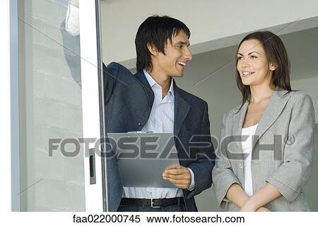 Male real estate agent showing house to female client, standing by sliding glass door, woman looking out, smiling View Large Photo Image Stock Photography - Male real estate agent showing house to female client, standing by sliding glass door, woman looking out, smiling. Fotosearch