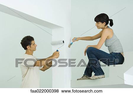 Stock Photo - Man and woman painting home interior together. Fotosearch