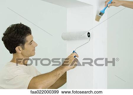 Stock Photo - Man and woman painting home interior together. Fotosearch