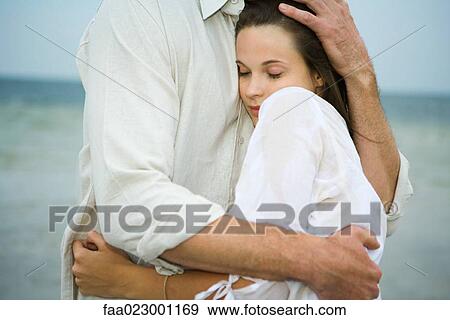 Man and young female companion embracing, close-up View Large Photo Image Stock Photo - Man and young female companion embracing, close-up. Fotosearch