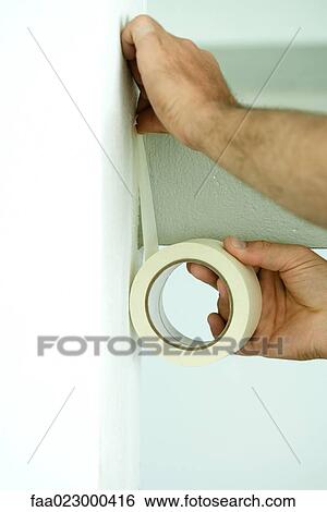 Man applying masking tape to wall, close-up of hands View Large Photo Image Stock Photograph - Man applying masking tape to wall, close-up of hands. Fotosearch