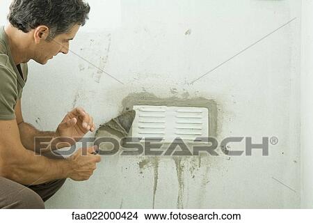 Man applying plaster around air vent View Large Photo Image Picture - Man applying plaster around air vent. Fotosearch