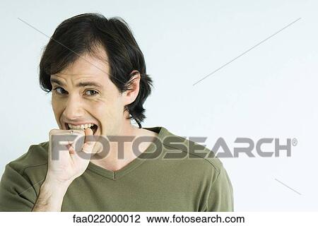 Man biting fist, raising eyebrows, portrait View Large Photo Image Stock Image - Man biting fist, raising eyebrows, portrait. Fotosearch