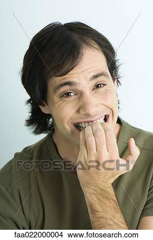Picture - Man biting nails, portrait. Fotosearch