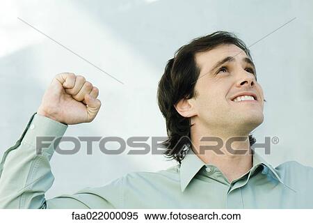 Man clenching fist, looking up, portrait View Large Photo Image Stock Photography - Man clenching fist, looking up, portrait. Fotosearch