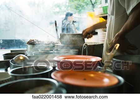 Stock Photo - Man cooking at outside stand, China. Fotosearch