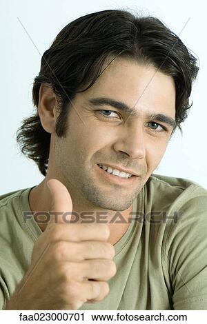Stock Image - Man giving thumbs up signal, smiling at camera. Fotosearch