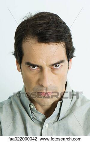 Stock Image - Man glaring at camera, portrait. Fotosearch