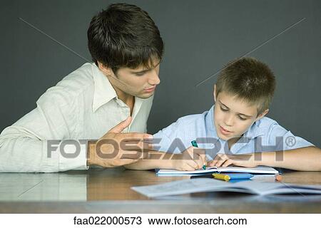 Man helping boy with homework View Large Photo Image Stock Image - Man helping boy with homework. Fotosearch
