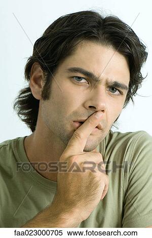Man holding finger over lips, looking at camera, portrait View Large Photo Image Stock Photography - Man holding finger over lips, looking at camera, portrait. Fotosearch