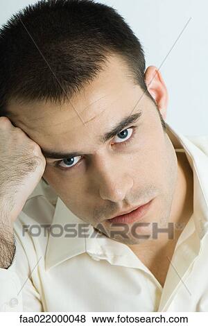 Man holding head, looking at camera, portrait View Large Photo Image Stock Photo - Man holding head, looking at camera, portrait. Fotosearch