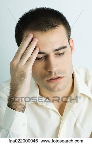 Stock Photograph - Man holding head, portrait. Fotosearch